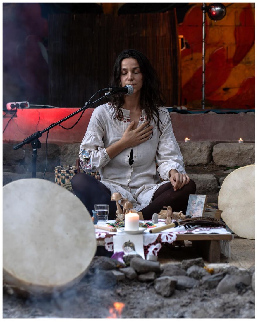 Benvinda a cantar com a mão no coração, entre tambores e velas